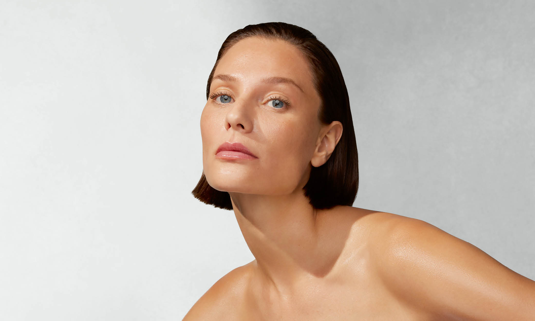 Frau mit nackten Schultern blickt frontal