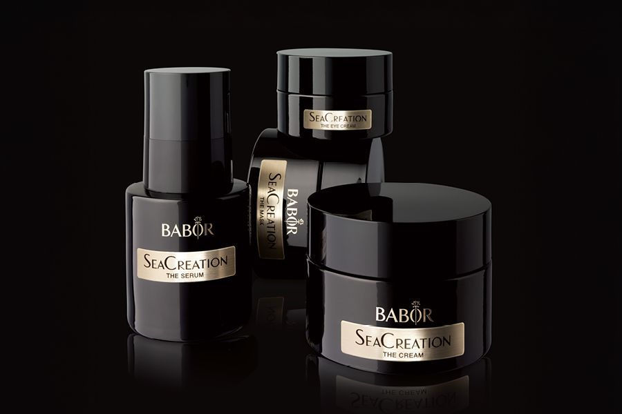 Vier schwarze BABOR SeaCreation Produkte nebeneinander und aufeinander gestapelt